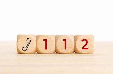 112 emergency concept. Wooden dices with phone icon and 112 text. Copy space white background